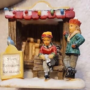 Festive Figurine with Children At Skate Rental Booth For Christmas Village